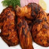 Charcoal Tandoori Chicken · Exotic chicken legs marinated in lemon juice, yogurt, and aromatic spices.