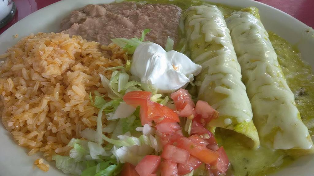 Enchiladas Suizas · Two corn tortillas rolled and stuffed with chicken and cheese, topped with melted Monterrey jack cheese, green tomatillo sauce, and sour cream.