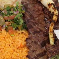 Carne Asada · Thin slices of skirt steak grilled and garnished with green onions and guacamole.