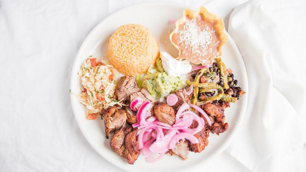 Pork Carnitas · Braised pork topped with a delightful mild tomato salsa and pickled onions. Served with rice, beans, and sour cream and guacamole.