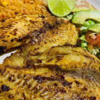 Pescado A La Plancha · two grilled  seasoned  tilapia fillets served with a small salad rice and beans garnished wi...