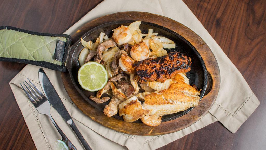 Mar Y Tierra · Tender strips of marinated chicken, steak, shrimp, tilapia, and chorizo, served on a bed of sautéed onions.