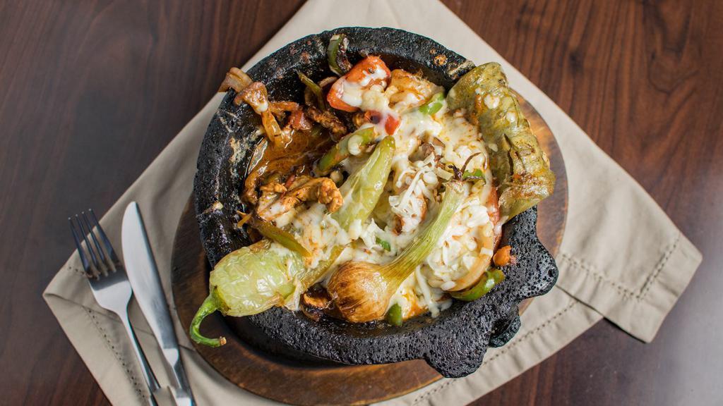 Molcajete Special · Grilled chicken or steak, sautéed with onions, tomatoes, and your choice of jalapeño, poblano, or bell pepper, topped with ranchero, chipotle, or tomatillo sauce, garnished with cambray onions, cactus leaf, and slice of chihuahua cheese, served with whole beans and tortillas.