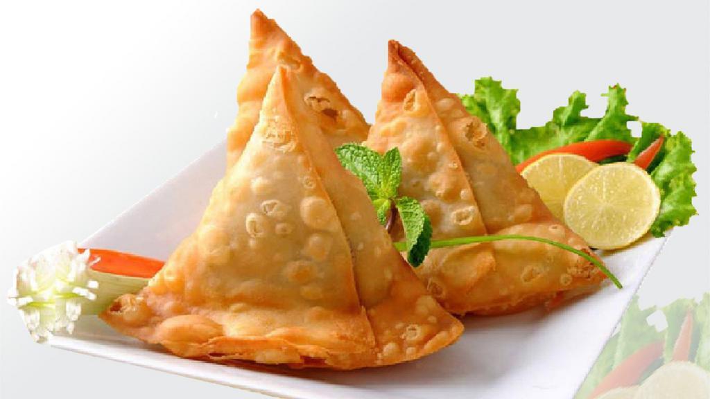 Lamb Samosa · Turnover stuffed with ground lamb, peas and spices, served with tamarind sauce and onion chutney.