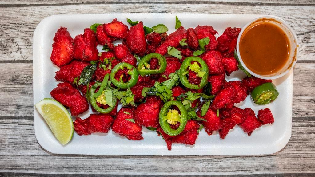 Chicken 65 · Boneless chunks of chicken marinated in garlic, ginger and other mild seasonings, then butter fried and topped with green chilies, cilantro and curry leaves.