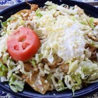 Nacho Supreme · A pile of nachos mixed with juicy shredded chicken, ground beef, homemade refried beans, fre...