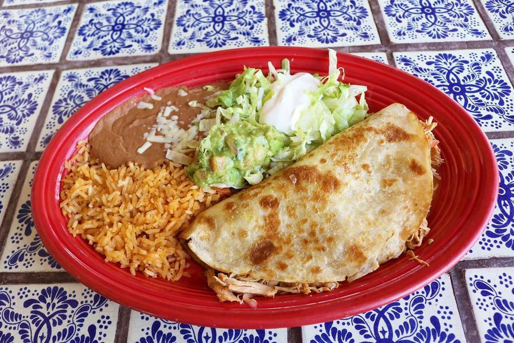 Quesadilla Special · Grilled flour tortilla stuffed with shredded chicken or ground beef, topped with lettuce, sour cream, and fresh guacamole with a side of fresh rice and homemade refried beans.