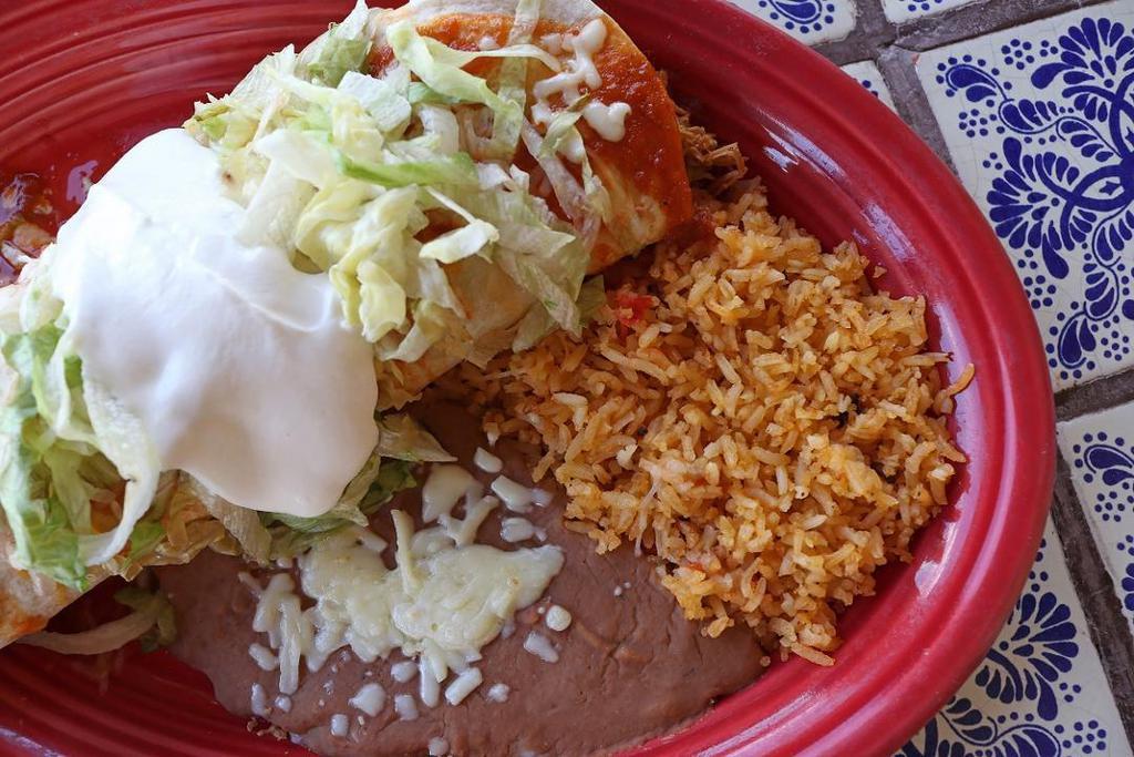 Big Mamma Burrito · A large flour tortilla filled with our juicy shredded chicken, topped with our signature burrito sauce, lettuce, shredded cheese, and sour cream. Served with a side of fresh rice and homemade refried beans.