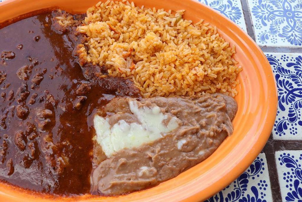 Chile Colorado · A spicy traditional dish of tender beef chunks covered in a secret red chili sauce, served with fresh rice, homemade refried beans, and your choice of corn or flour tortillas.