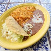 Lunch Taco · A crunchy or soft taco shell filled with your choice of ground beef or shredded chicken, top...