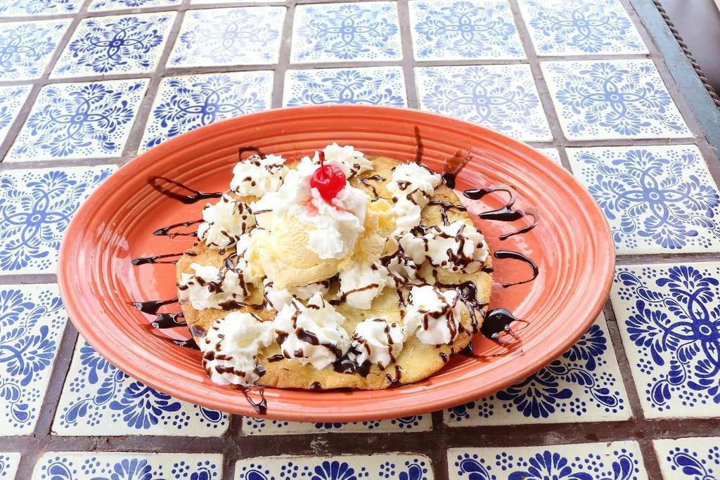 Sopapilla With Ice Cream · A delicious fried flour tortilla topped with a scoop of soft vanilla ice cream, honey, cinnamon sugar, chocolate syrup, whipped cream, and a cherry.