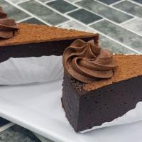 Chocolate Torte · A rich and fudgy flourless chocolate cake, dusted with cocoa and garnished with chocolate bu...