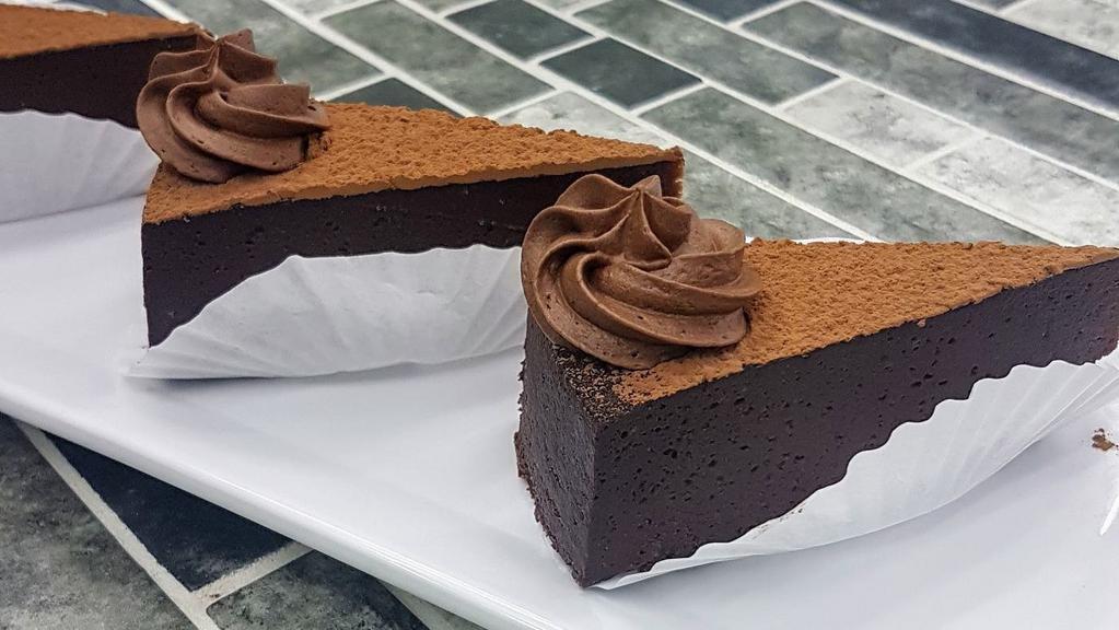 Chocolate Torte · A rich and fudgy flourless chocolate cake, dusted with cocoa and garnished with chocolate buttercream.  (gluten-free) LIMIT 3 PER ORDER