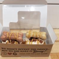 Doggy Donuts · Box of 2 donuts topped with peanut butter frosting, bacon, a dog biscuit and peanut butter d...