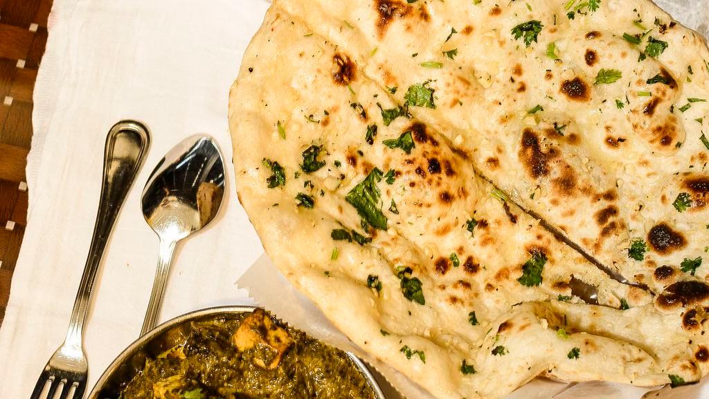 Garlic Naan · White flour bread topped with garlic and parsley, cooked in a clay oven.