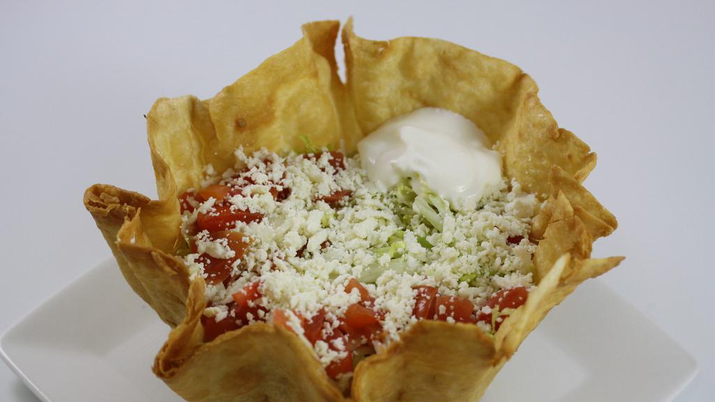 Taco Salad · A flour taco shell stuffed with rice, refried pinto beans, lettuce, pico de gallo, queso fresco, sour cream and fresh guacamole. Served with your choice of meat. (chicken, steak, ground beef, chipotle chicken, carnitas, chorizo).