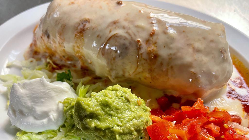 Chimichanga · A deep-fried burrito prepared with your choice of meat and topped with melted cheese. Served with lettuce, pico de gallo, sour cream, fresh guacamole, rice and refried pinto beans.