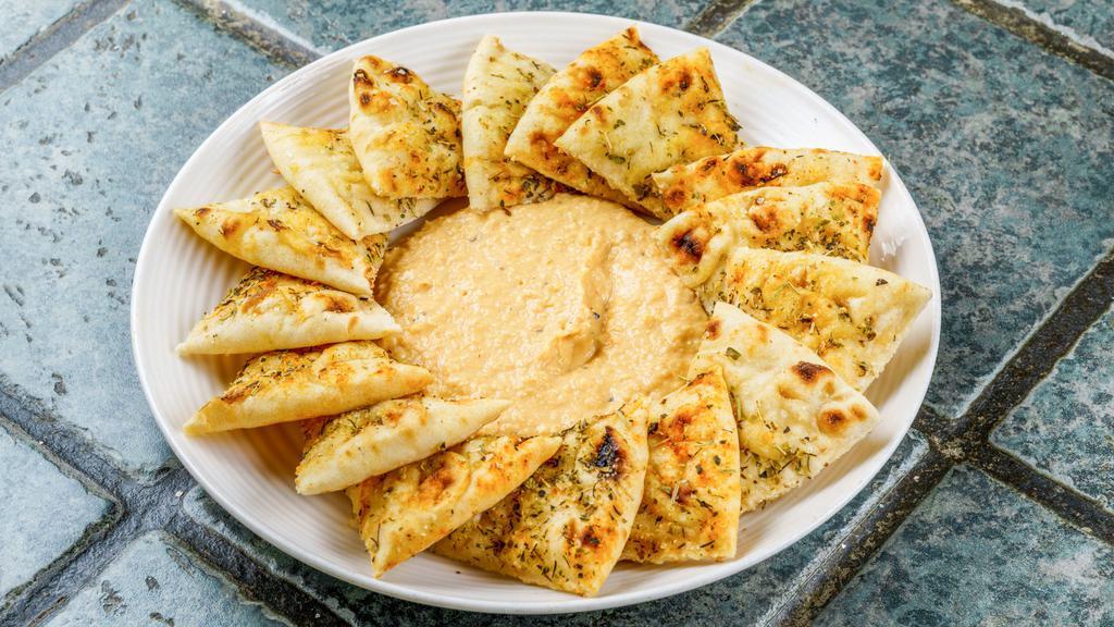 Pita And Hummus Plate · Seasoned pita chips with a side of hummus.