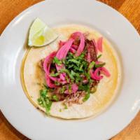 Carnitas · Michoacán style braised pork, pickled red onions, Mexican rice and refried beans.