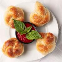 Garlic Knots · Our homemade dough baked and tossed in fresh garlic, olive oil and sea soned parmesan cheese...