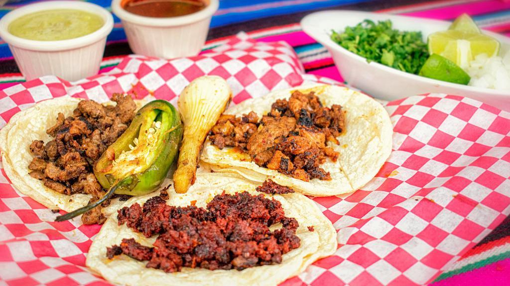 Tacos · soft corn tortilla with your choice of meat served with onion, cilantro and limes with green and red salsa on the side.