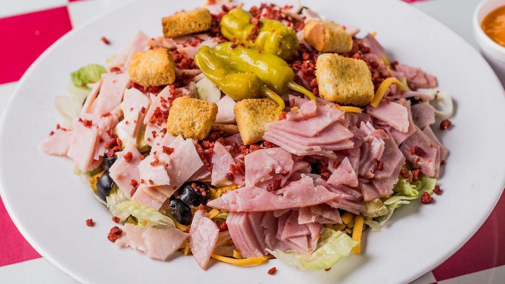 Chef Salad · Mixed greens topped with smoked turkey, ham, tomatoes, cheese, eggs, black olives, bacon bits and croutons.