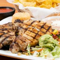 Grilled Pork Chops · Wrapped with bacon and grilled onions served with two choices of sides and guacamole salad.