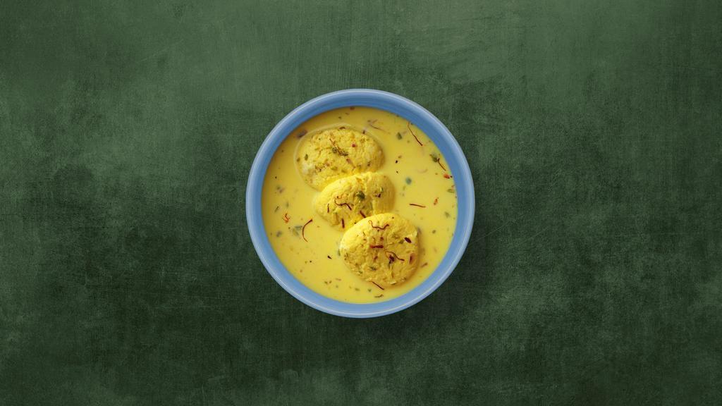 Real Rasmalai · Creamy village cheese patties immersed in chilled flavored milk, topped with chopped nuts.