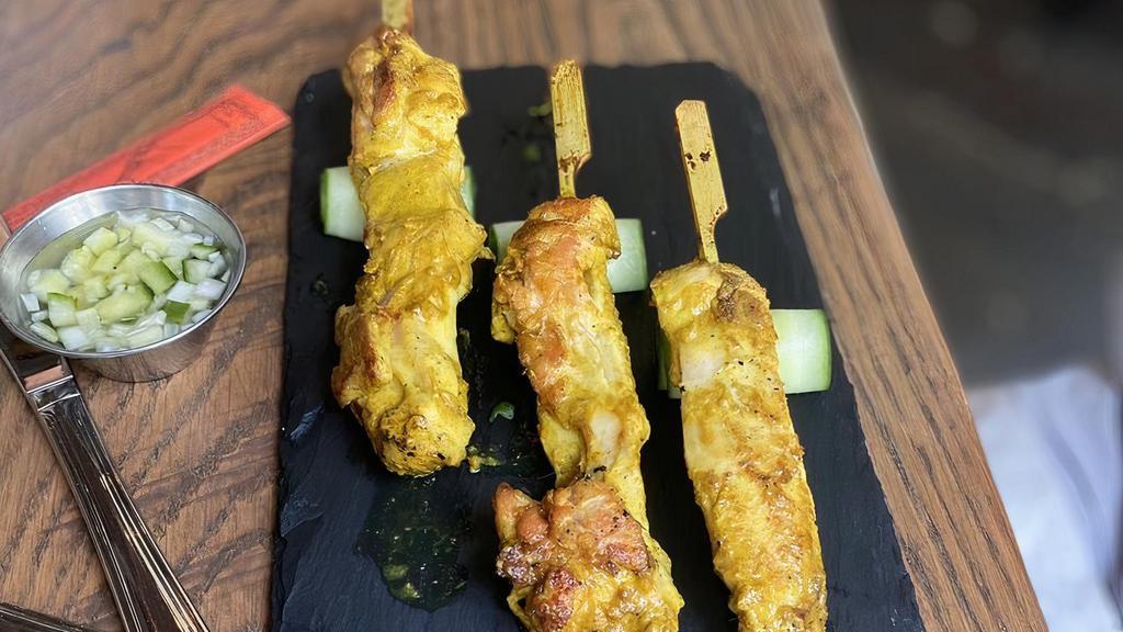 Chicken Satay Skewers (4 Count) · Skewered chicken thigh, yellow curry coconut marinade, cucumber shallot vinaigrette