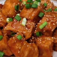 Sesame Chicken · Lightly battered chicken stir-fried with sesame seeds in a tomato-based sauce.