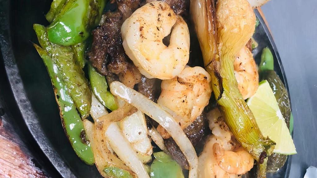 Steak & Shrimp · 12 oz. rib eye steak with grilled shrimp on a bed of grilled peppers and onions. Served with rice, lettuce, avocado, pico de gallo, jalapeño and lime.