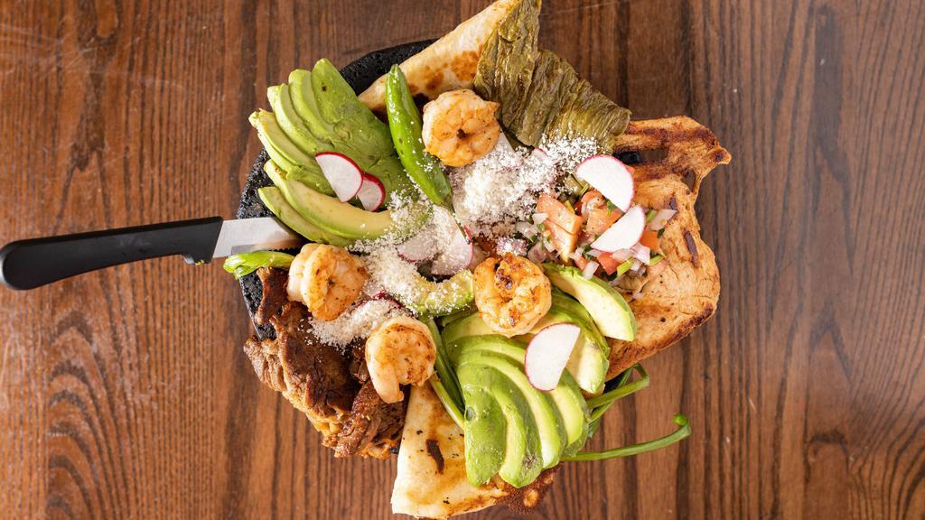 Molcajete · A grilled chicken breast, a piece of carne asada, chorizo with nopales, spring onions, banana peppers, jalapeño peppers, a cheese quesadillas and avocado slices served with beans, lettuce, tomatoes, rice, sour cream and tortillas.
