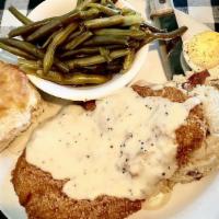 Country Fried Steak · Served over mashed potatoes and smothered in white pepper gravy and your choice of side.