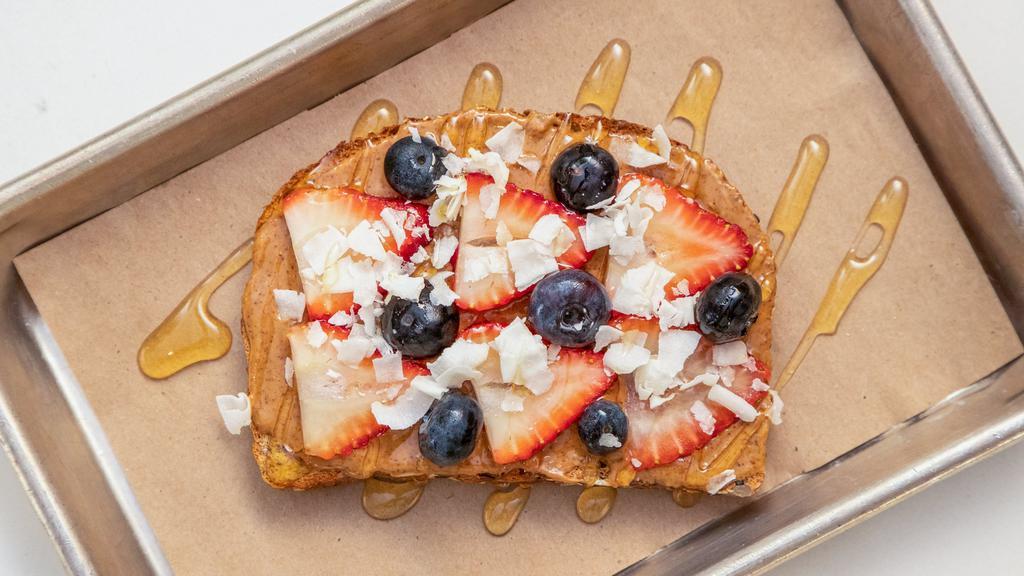 Almond Berry Toast · Almond butter topped with strawberries, blueberries, coconut flakes and agave, on organic multi-grain bread.