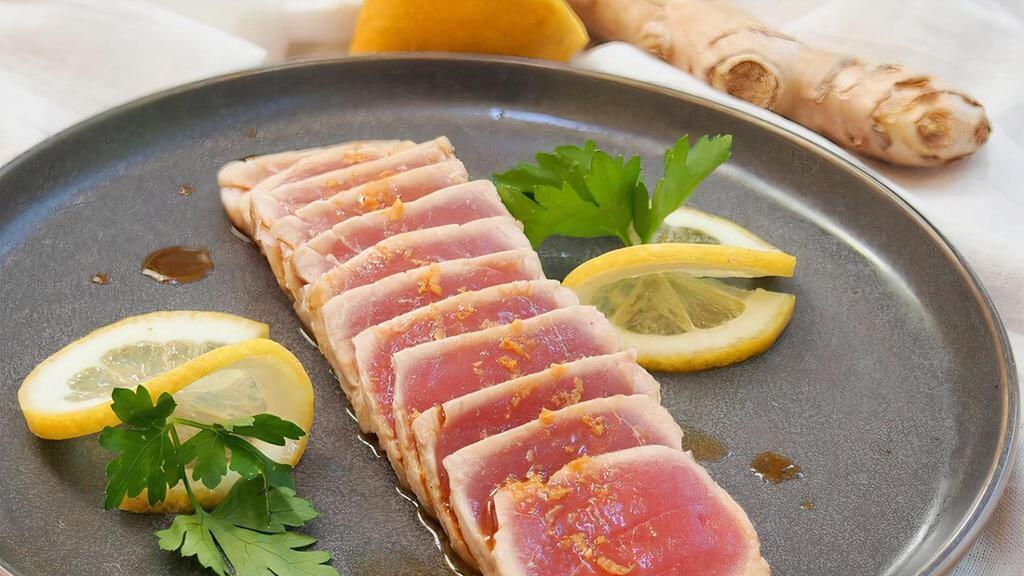 Tuna Tataki · Slice seared pepper tuna on top of slice cucumber with masago, scallion and ponzu sauce.