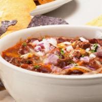 Chili With Cornbread - Bowl · Hearty and delicious. Topped with red onions and cheddar cheese and served with cornbread.