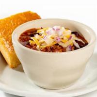 Chili With Cornbread - Cup · Hearty and delicious. Topped with red onions and cheddar cheese and served with cornbread.