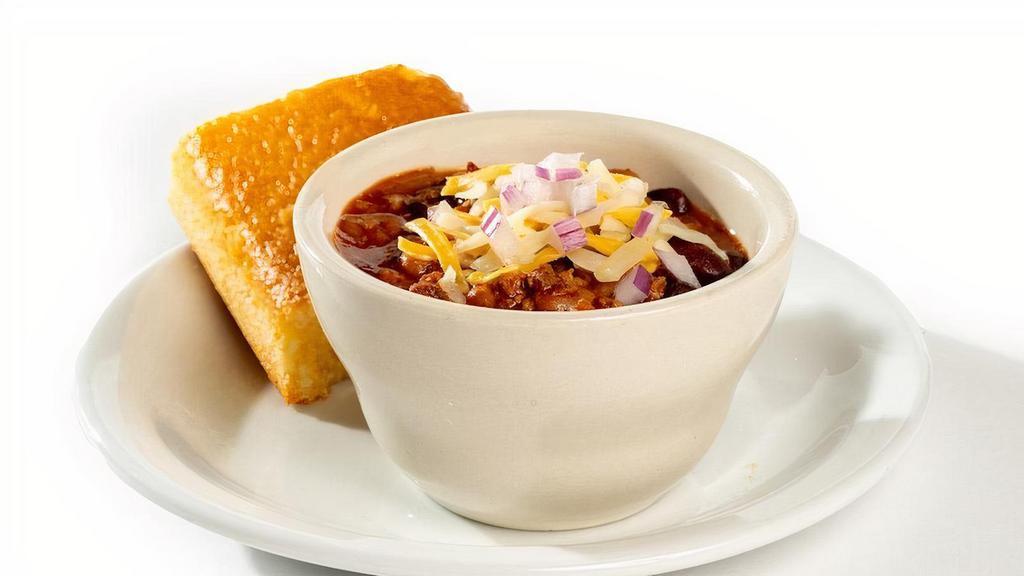 Chili With Cornbread - Cup · Hearty and delicious. Topped with red onions and cheddar cheese and served with cornbread.