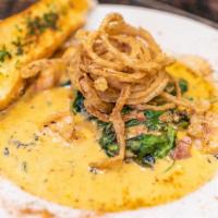 Low Country Shrimp & Grits · Sautéed with garlic, country ham, and arugula over creamy smoked grits.