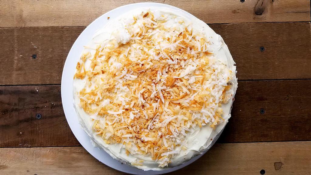 Coconut Cake · Classic coconut layer cake topped with rich cream cheese icing and dusted with coconut flakes. Limited stock daily. Pictured whole; served in slices. 

ALLERGEN WARNING: prepared and stored in an environment where cross-contact with tree nuts is possible