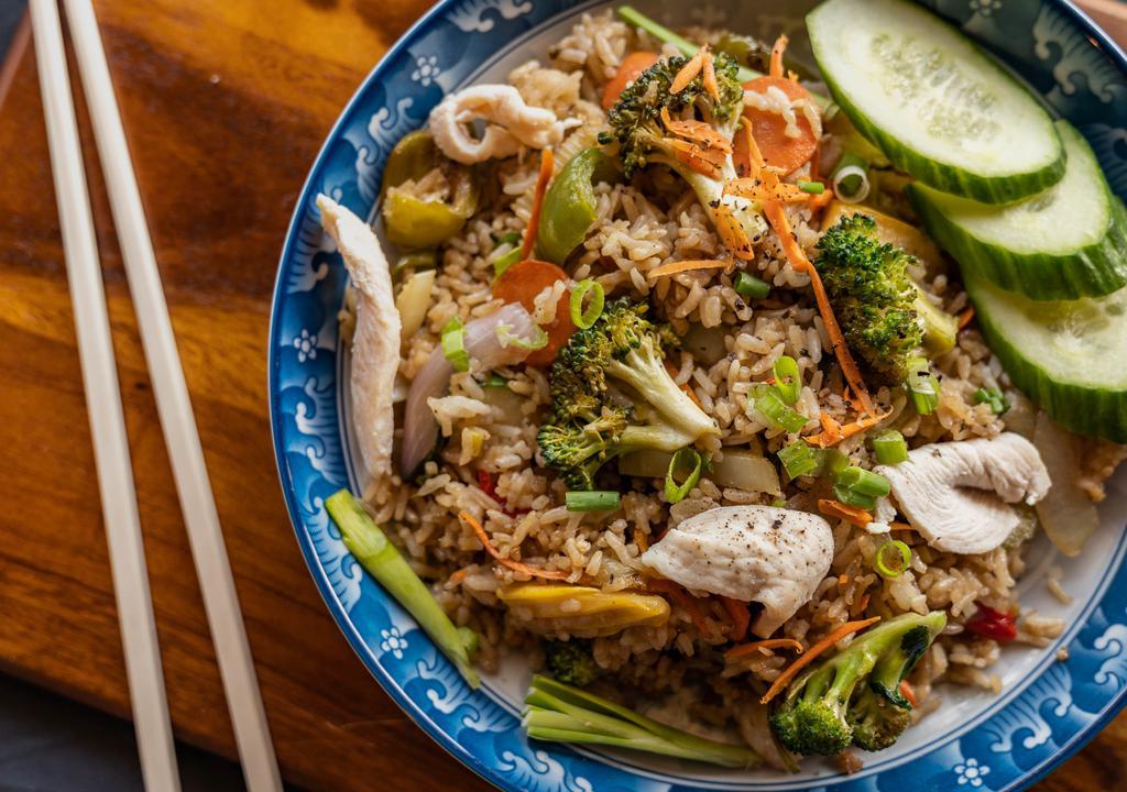 Chicken Thai Fried Rice · Stir fried rice, broccoli, onion, green onion topped with sliced cucumber, tomatoes, and a dash of black pepper. Comes with soy sauce.  Add egg optional
