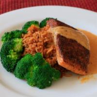 Cajun Salmon · Blackened salmon filet served over red rice and broccoli . Finished with a cajun cream sauce.