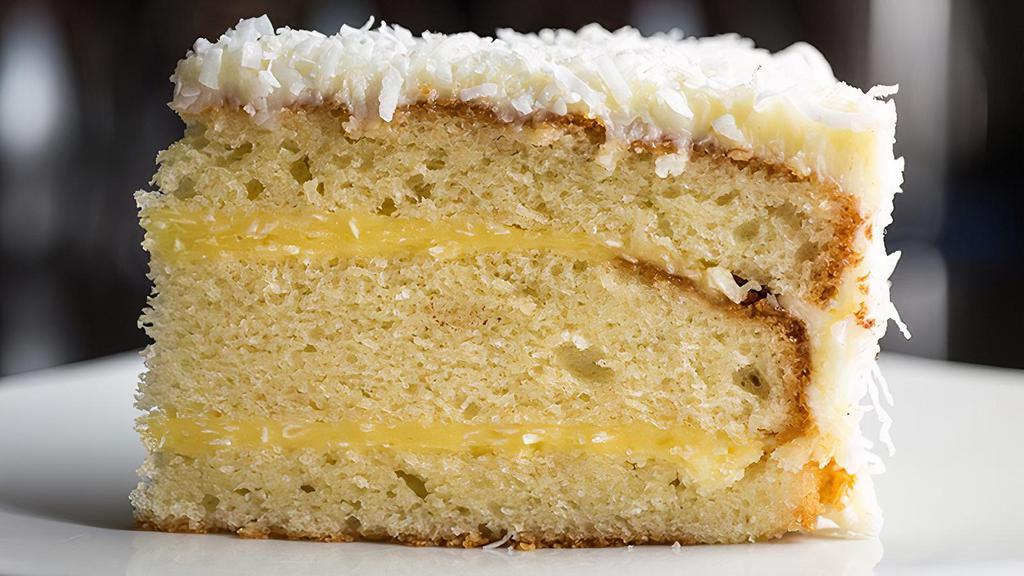 Coconut Cake · Three layers of moist buttery yellow cake and creamy coconut pastry cream with cream cheese frosting. Sprinkled with sweetened white flaky coconut.