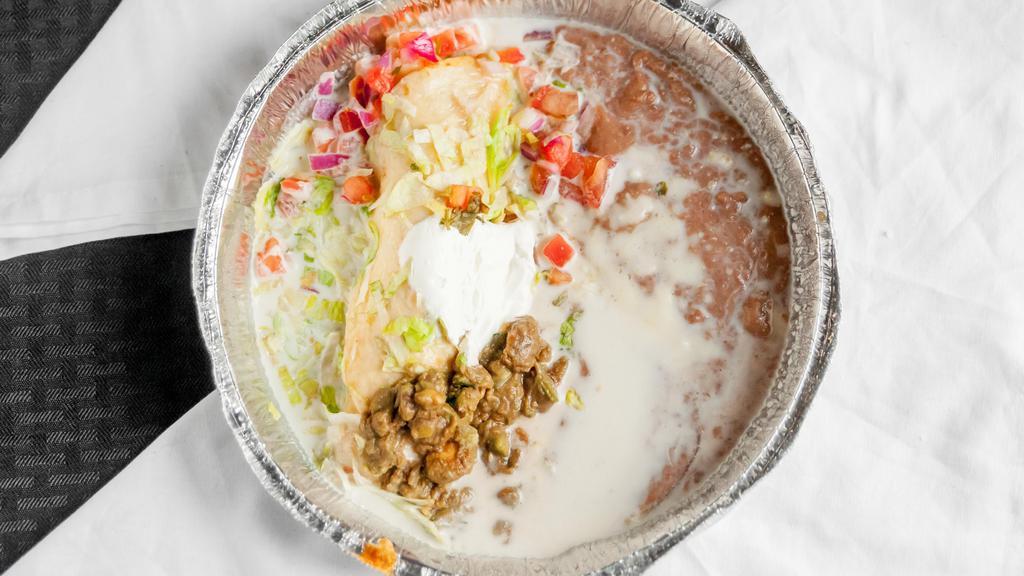 Chimichanga · Choice of soft or fried. Large flour tortillas filled with beef or chicken, topped with sour cream, nacho cheese, and guacamole salad. Served with refried beans.