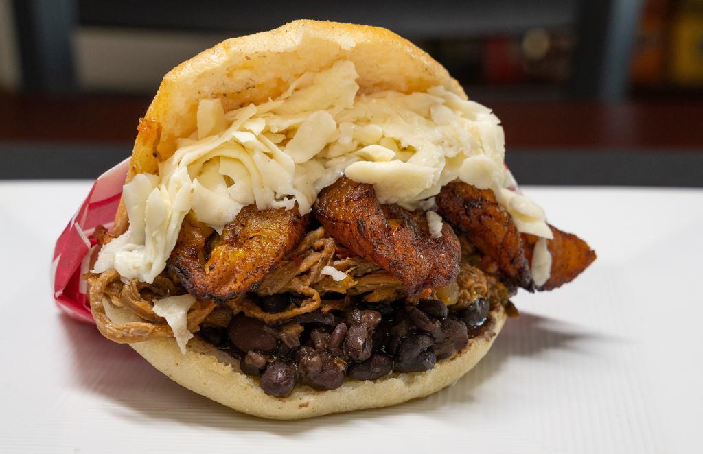Arepa Pabellón · Arepa con caraota, carne mechada, queso y platano frito / Arepa with black beans, shredded beef, white cheese and fried sweet plantain.