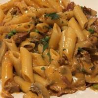 Penne Alla Vodka · Penne pasta in a roast plum tomato cream sauce laced with absolut vodka mixed with Parmigian...