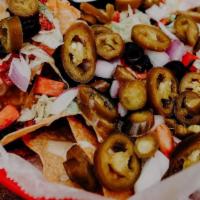 Nachos · Homemade tortilla chips topped with shredded cheese, queso, lettuce, tomato, onion, black ol...