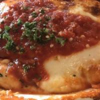 Pollo Parmigiana · Chicken cutlets lightly breaded and fried, baked in tomato sauce topped with mozzarella. Ser...