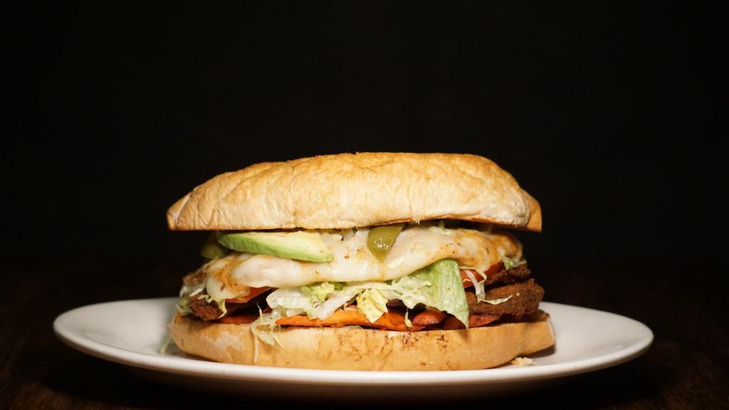 Torta Suprema · Includes BOTH milanesa de pollo (breaded chicken), milanesa de res (breaded steak), and it includes Al Pastor as well. Ingredients include lettace, tomatoes, avacado, onion, and melted cheese. This is the ultimate torta.