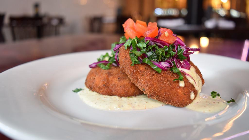 Crab Cakes · Fresh blue crab meat cakes, fried and topped with a louisiana crawfish cream sauce.